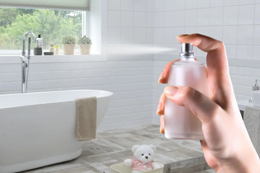 Tangan menyemprotkan pengharum kamar mandi