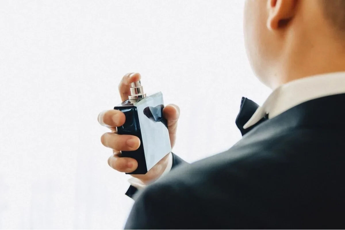 orang yang sedang menyemprotkan parfum