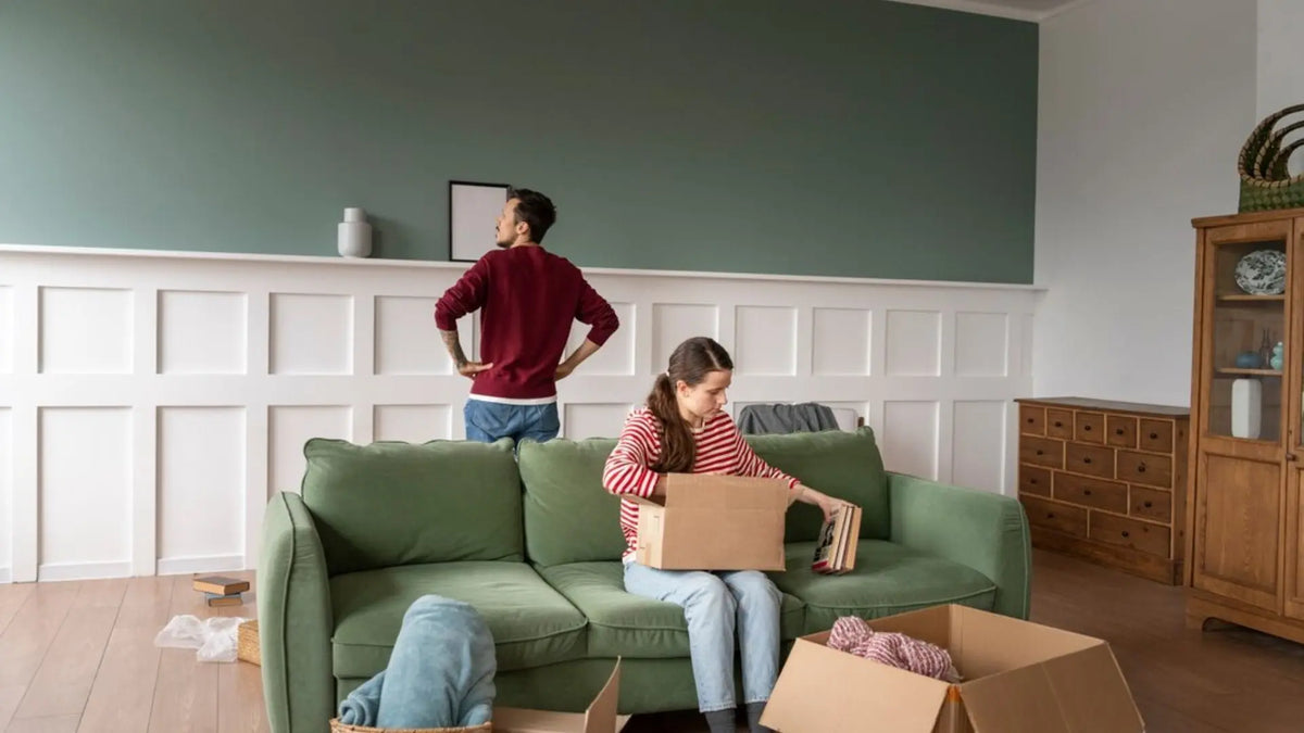 dua orang yang sedang membereskan barang saat pindah rumah